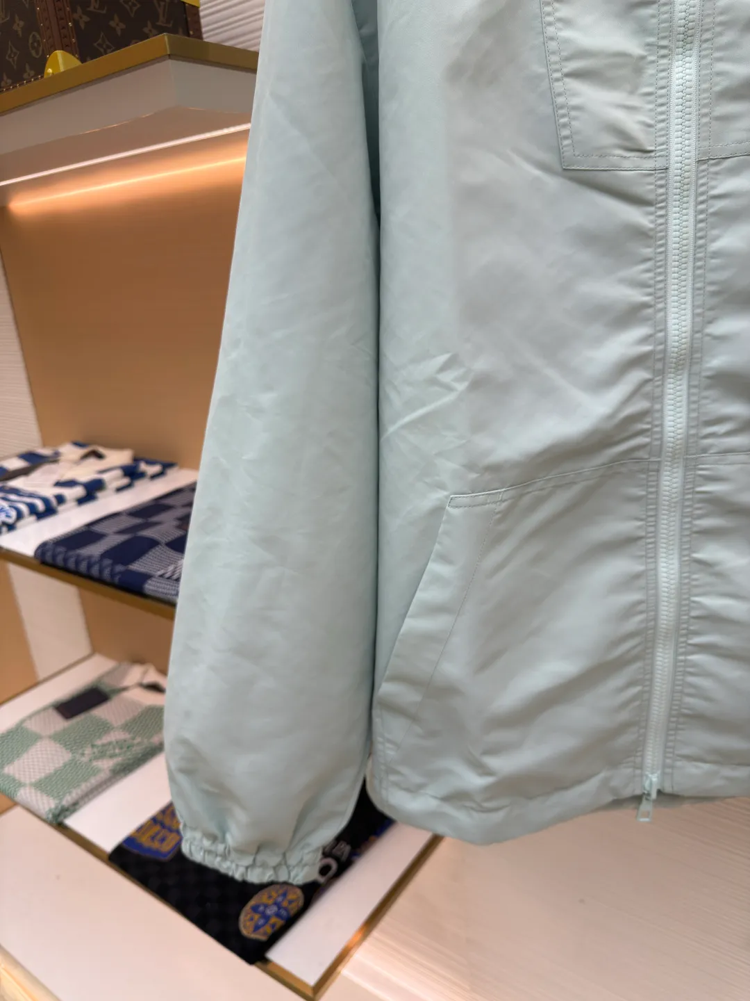 LOUIS VUITTON double-sided windproof pin jacket ●Authentic product: purchased and developed for 22800 ●Item number: 1680473-C55 ●Fabric: polyester fiber fabric ●Technology: jacquard ●Version: fitted version ●Weight: about 565 grams ●Size: 44-46-48-50 ●Description: The solid color fabric is made of nylon encrypted matt twill fabric, and the jacquard fabric on the other side is made of 50D nylon yarn-dyed jacquard fabric. The solid color front panel is laser-burned, hand-made of white copper, with a triangle pin with logo and glossy finish. The front panel pocket uses a hardware keychain to hang a folding clothing tag, and the jacquard letters on the front chest placket are made of single-piece flowing pure It is cut by hand to restore the flower, and all the pieces are numbered. The pockets are also cut with the restored flower number. The fabric is relatively light and silky, and it takes time to cut accurately. The front and center are equipped with a double-circulation puller 5# orbital zipper. The hem and the hood are worn with spiral elastic ropes with ring anti-slip buckles, square pig nose buckles with logo, and all holes are punched with hardware and logo on the cloth-colored cornrows.